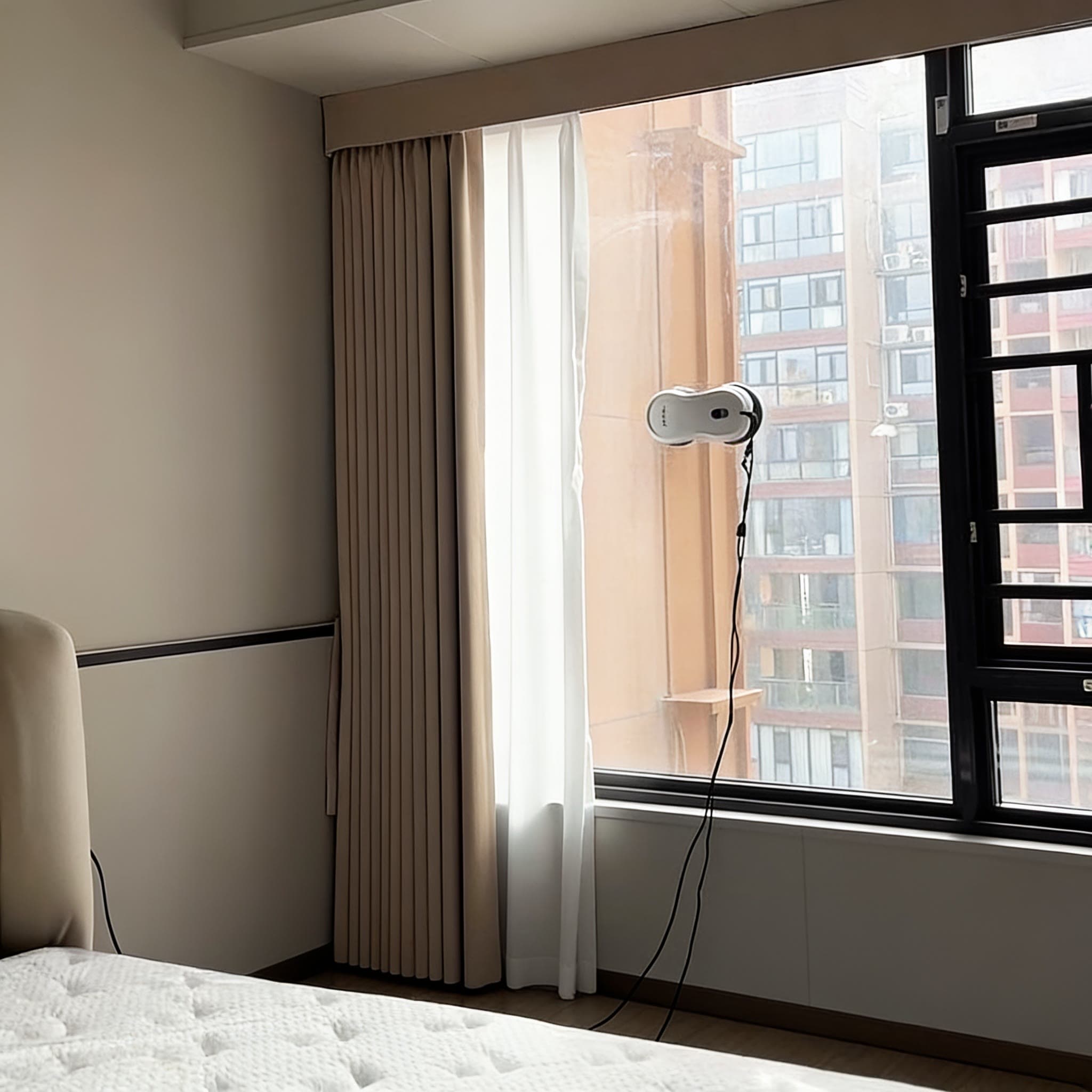 Le robot lave la grande fenêtre d'une chambre
